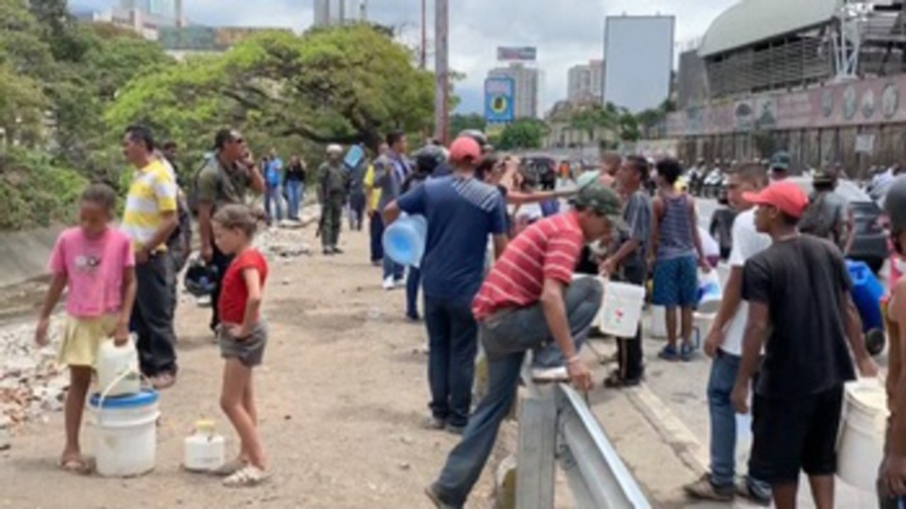 Habitantes de Caracas recogen agua en río contaminado debido a la escasez por apagón