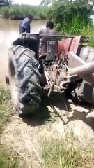 Il traverse une rivière avec un tracteur