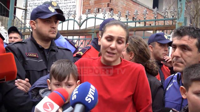 Një punonjëse e forcave Shqiponja mes banorëve, të cilëve po i shembet shtëpia