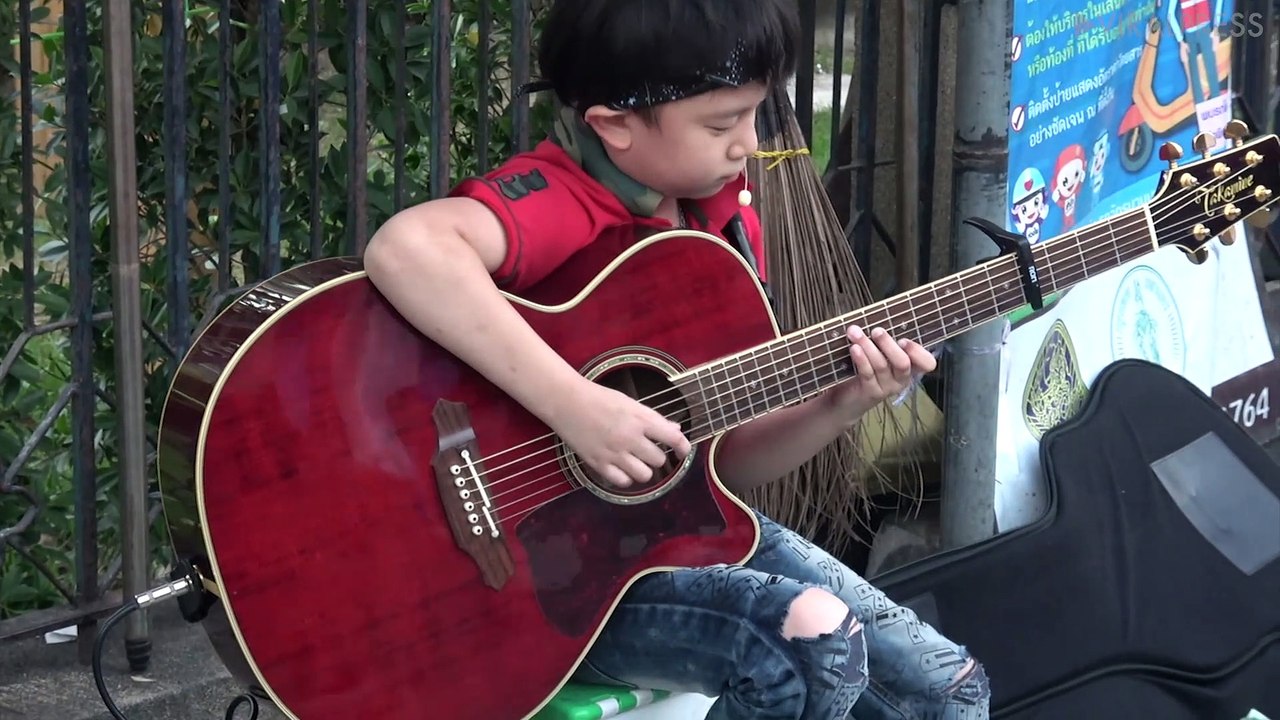 Busker Kid Rocks Out With Acousic Guitar
