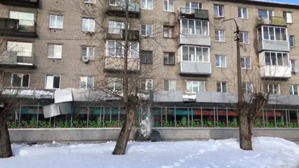 Des ouvriers détruisent la devanture d'un supermarché en déneigeant le toit du bâtiment