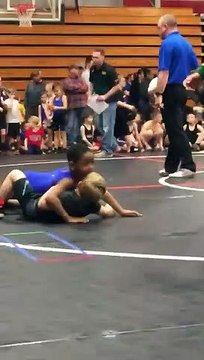 Un petit lutteur fait une prise de catch