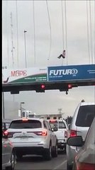 realiza una peligrosa hazaña, colgado de un cable sobre el puente peatonal