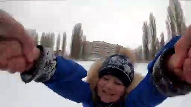 Un papa fait tourner son enfant dans la neige (POV)