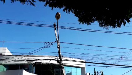 Poste fica suspenso após ser atingido por carro