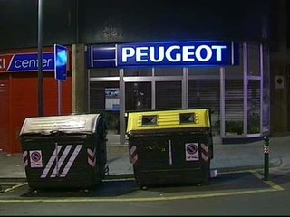 Encapuchados incendian contenedores y apedrean un concesionario de coches en Bilbao