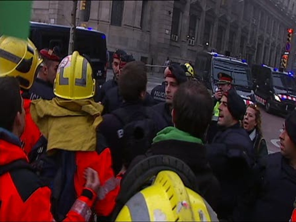Mossos y bomberos forcejean durante una manifestación