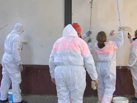 Un barrio movilizado para borrar los grafitis de sus fachadas.