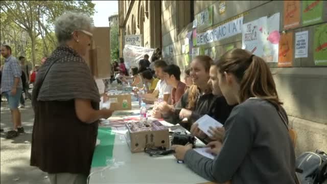 Estudiantes de la Universidad de Barcelona (UB) reparten papeletas para votar el 1-0