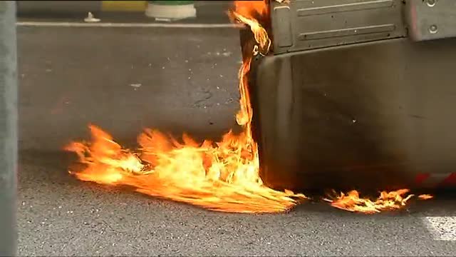 Un grupo de encapuchados quema un contenedor y destroza las lunas de un banco en la manifestación universitaria de Barcelona