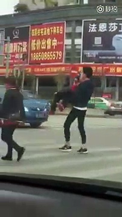 Il porte une mamie dans ses bras pour lui faire traverser la route. Beau geste