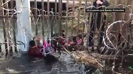 Migrant smugglers push families under US border fence