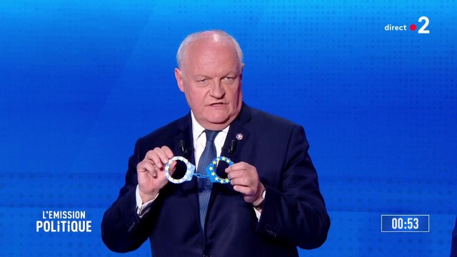 Premier à parler, François Asselineau présente une paire de menottes aux couleurs du drapeau européen