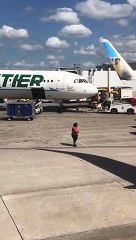 Elle danse entre les avions sur la piste de l'aéroport avec les bâtons de signalisation !