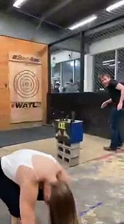 Une blonde lance une hache sur une cible