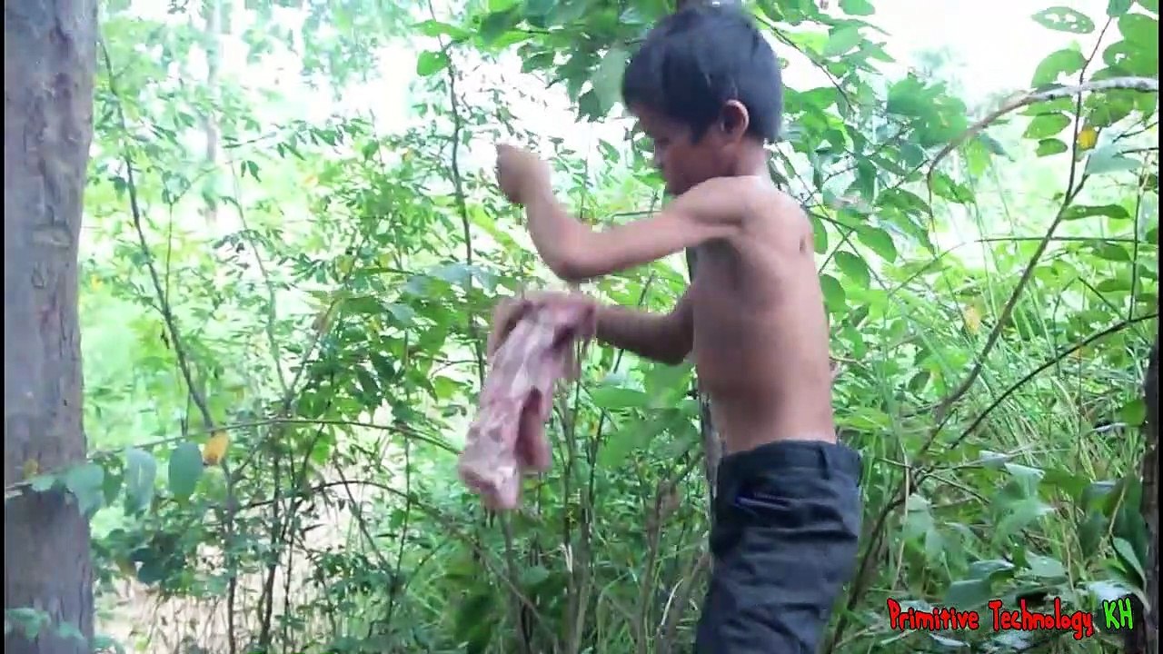 La Technologie Primitive Manger de délicieux la Cuisson des côtes de porc sur un rocher dans la forêt