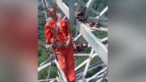 Chinese workers nap 50 metres above ground on transmission tower