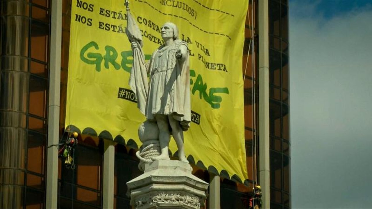 Greenpeace despliega una gran pancarta amarilla en las Torres de Colón