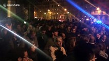 Parisians gather and sing hymns on the Tournelle Bridge opposite Notre Dame