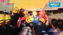 Rescue volunteers rush to a nearby medical facility a woman who was extricated from the rubble of the collapsed Chuzon Supermarket in Porac, Pampanga