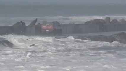 Скачать видео: Un conducteur idiot pense pourvoir rouler avec son 4x4 sur une jetée en pleine tempête... Raté