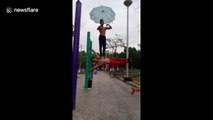 Insane workout! Fitness enthusiast bears man's weight on his waist as he performs a parallel bar exercise