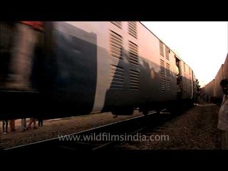 Black smoke billowing out of the engine in an Indian rail