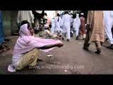 Out-stretched arms beg for alms on Eid near Jama masjid