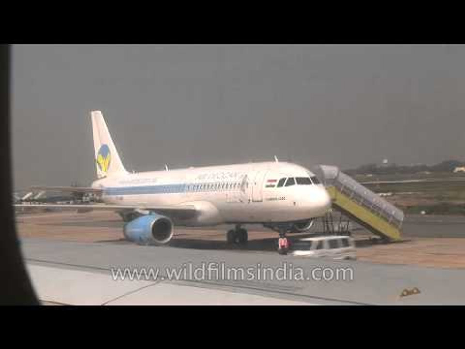 Air Deccan plane being boarded and Jet airways flight to Delhi taxiing at Kolkata Airport