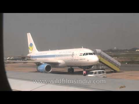 Air Deccan plane being boarded and Jet airways flight to Delhi taxiing at Kolkata Airport