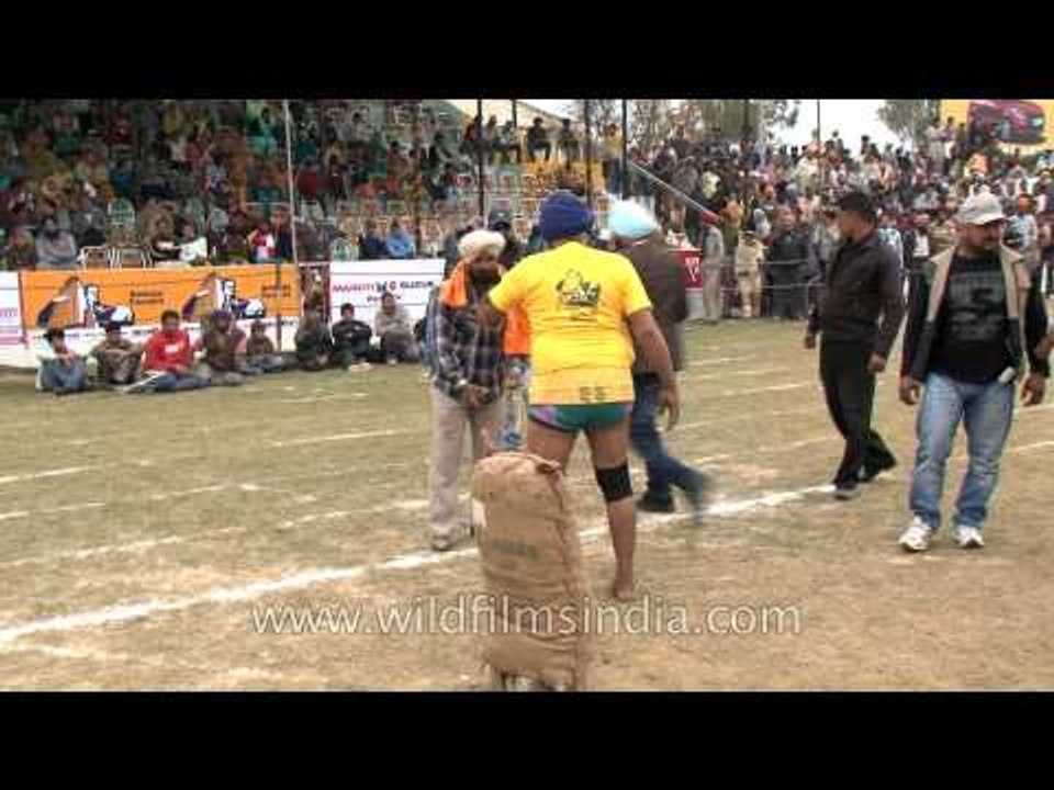 Old man lifts heavy sack in India : rural weight-lifting challenge