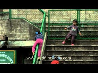 Sliding down Kellogg Church railing - happy girl children in Landour