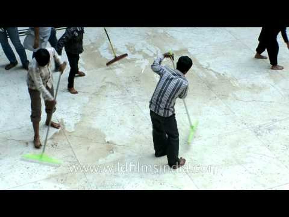 People cleaning floor for blood shed on Muharram