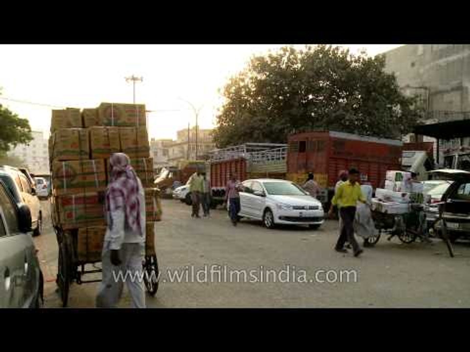 Fruits and veggies stacked up on tri-cycle goods carriers in the Azadpur mandi