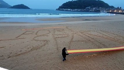 La playa de la Concha amanece con un 'Por España' y una rojigualda de 50 metros
