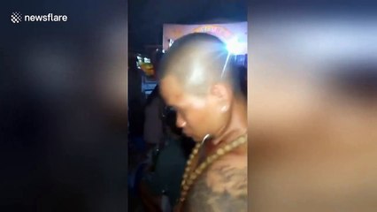 Vietnamese man uses iron hook on his neck to lift a 3kg cement pot