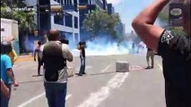 Anti-Maduro protesters run for cover as riot police fires tear gas in the streets of Caracas