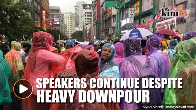 Speakers continue with their speehes at rally despite heavy downpour