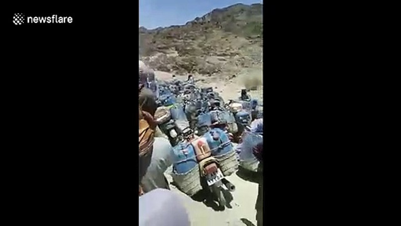 Huge line of fuel smugglers cross the border from Iran into Pakistan