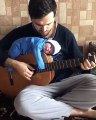 Il joue avec son bébé posé sur la guitare !
