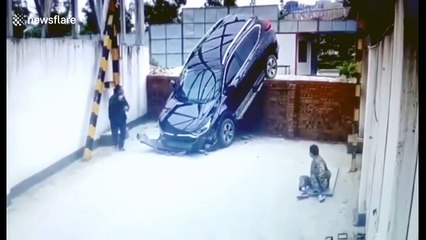 SUV driving off wall narrowly misses worker napping underneath