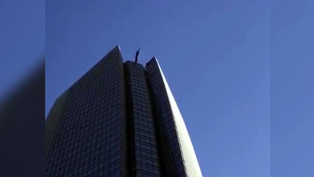 Dos limpiadores de ventanas quedan balanceándose en un ascensor en un rascacielos