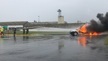 Les pompiers éteignent un feu de voiture en public