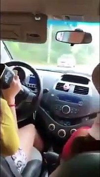 Đang lái xe trên đường người phụ nữ vẫn hồn nhiên cầm điện thoại và mic hát