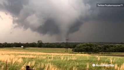 Onlookers film tornado in field