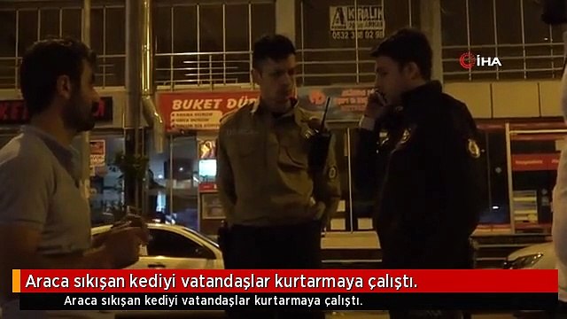 Araca sıkışan kediyi vatandaşlar kurtarmaya çalıştı.