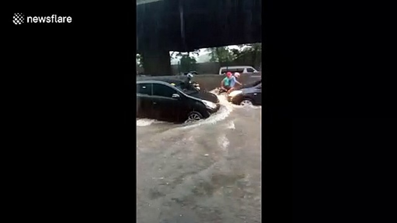 Motorists drive through heavy flash floods in the Philippines