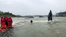 Chinese firefighters rescue workers trapped on flooded digger