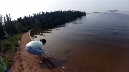 Elle remet un poisson à l'eau mais il va vite revenir dans ses bras... regardez pourquoi