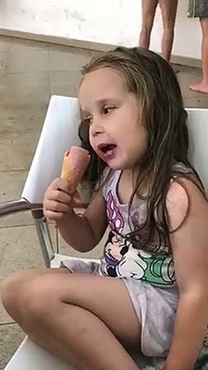 Une petite fille s'endort en mangeant sa glace